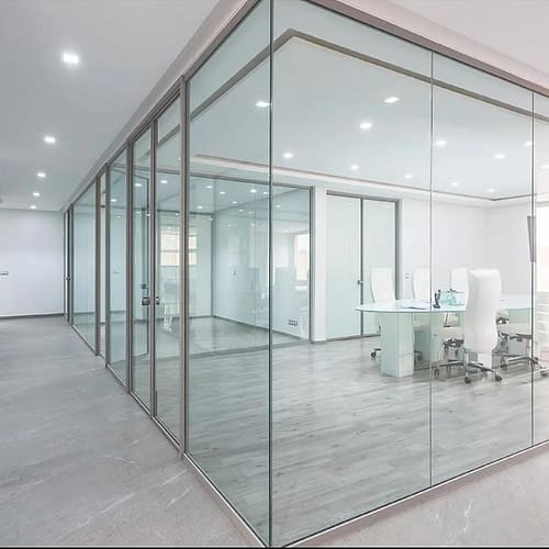 Office interior divided by full-height glass partitions in slim aluminium frames