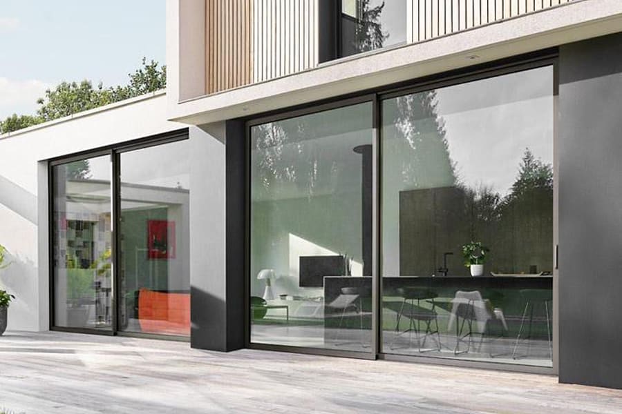Wide aluminium sliding glass doors opening from a living room onto a terrace
