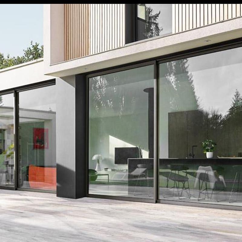 Large aluminium sliding doors connecting a living space to a terrace