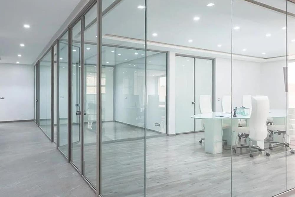 Full-height glass partitions forming office cabins with slim aluminium framing